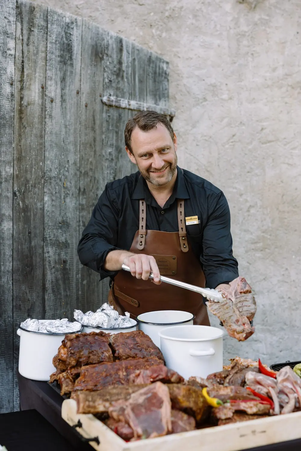 Head Grill Master Honza with tongs over ribs and steaks