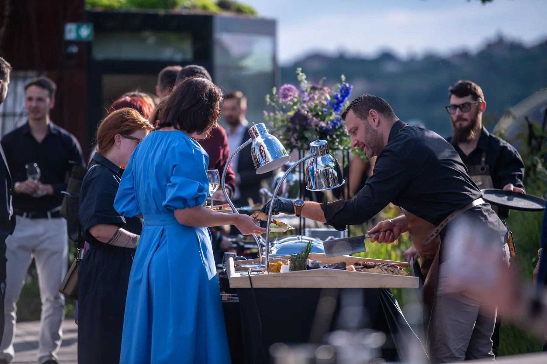 Honza serving guests at a rooftop corporate event